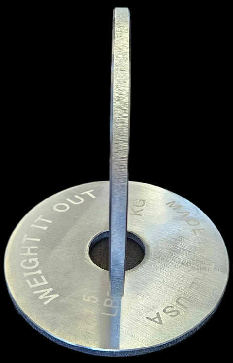 Two Solid Steel Loadable Dumbbell weight plates by Weight It Out are shown—one upright, one flat with “WEIGHT IT OUT, 5 LB, MADE IN USA” text visible. Ideal for adding precision weights to your training routine.