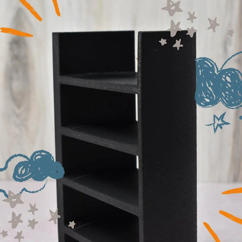 The Chatelet Manufacturing Lid Organizer for Stanley Cup lids holds five lids and straws in a sleek black, rectangular design, shown upright against a light wood background with playful blue clouds, orange lines, and gray stars. Made in USA.