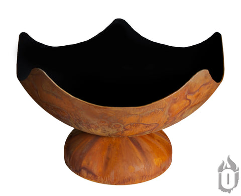 The Stellar Artisan Fire Bowl by Ohio Flame is a large, rust-toned carbon steel fire pit with petal-like edges, a black interior, and features the flame-shaped Ohio Flame logo on the bowl’s base. Made in the USA.