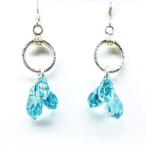 The Sterling Silver Hammered Aqua Crystal Cascading Drop Earrings by Alexa Martha Designs feature three faceted blue crystals each, displayed against a white background.
