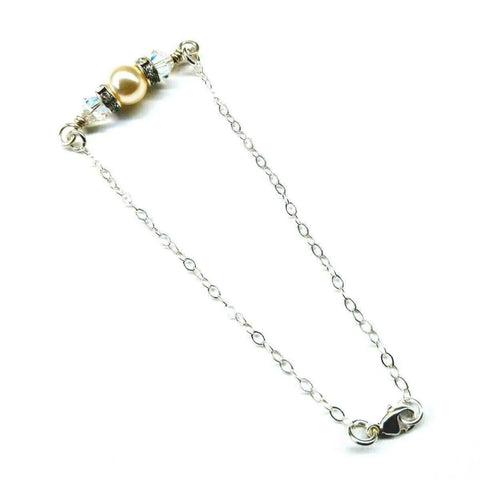 The Silver Swarovski Crystal Pearl Bar Bridal Bracelet by Alexa Martha Designs features a silver chain, central gold pearl bead, clear Swarovski crystals, silver accents, and a lobster clasp on a white background.