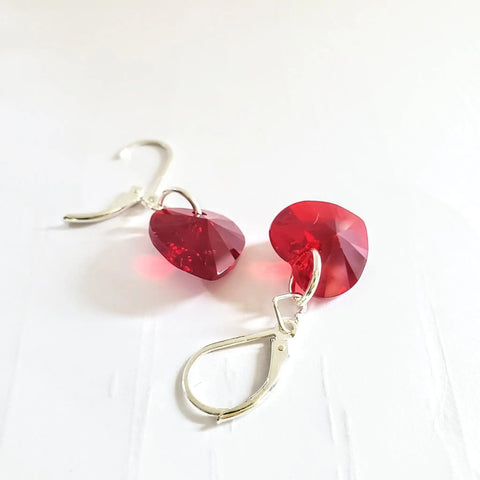 Sterling Silver Red Heart Crystal I Love You Jesus Earrings by Alexa Martha Designs feature faceted red Swarovski Crystal hearts on leverbacks, shown on a white textured surface.