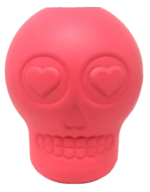 The Sugar Skull EDispenser by SodaPup is a durable pink rubber chew toy and treat dispenser for dogs, featuring heart-shaped eyes, a smiling mouth, and smooth, stylized details—perfect for playful pups.