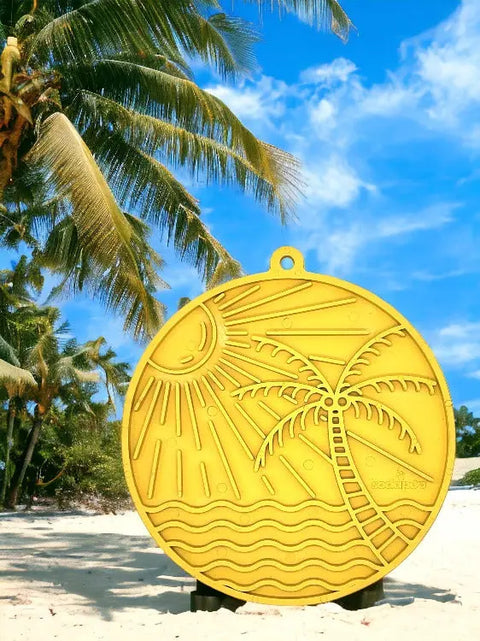 The SodaPup Sun N Sea EMat Enrichment Lick Mat With Suction Cups, featuring a carved beach and palm tree design, resembles a playful dog treat mat and stands out brightly under palm trees on a sandy beach.