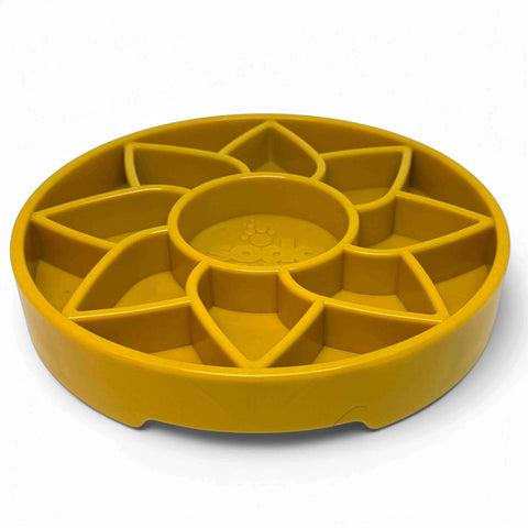 The SodaPup Sunflower Design ETray is a yellow, round, shallow slow feeder dog bowl with a raised flower pattern for enrichment that divides the interior for slow feeding.