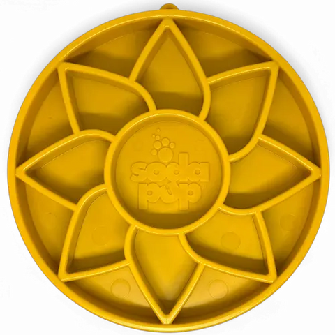 The SodaPup Sunflower Design ETray is a round, yellow silicone shallow slow feeder dog bowl with eight petal-shaped sections, a circular paw print-embossed center, and perfect for enrichment.