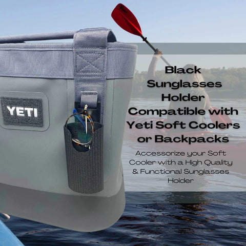 A Chatelet Manufacturing Sunglasses Holder Attachment is shown on a gray Yeti soft cooler by a lake, as someone kayaks in the background. Compatible with soft Yeti coolers and backpacks with straps. Made in USA!.