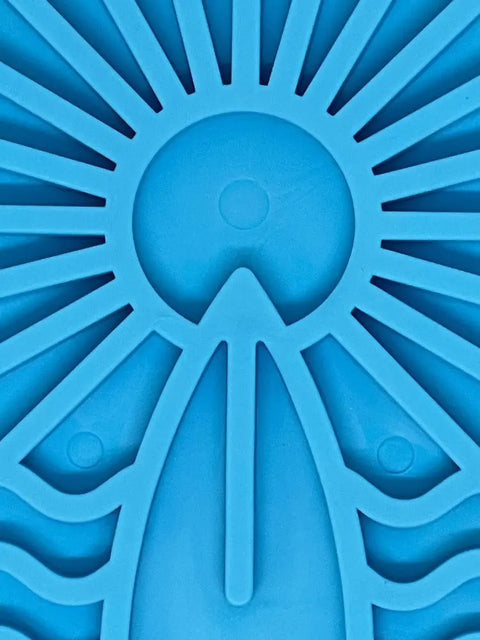 Close-up of a blue abstract pattern with a central circle and wavy lines, echoing a sun—ideal inspiration for the SodaPup Surfs Up Design EMat Enrichment Lick Mat - Small to foster canine enrichment and natural foraging behaviors.