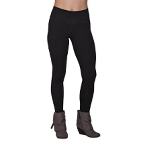 A person wears Spiritex | Sustainable Apparel Yoga Leggings in black with gray ankle boots, shown waist down against a white background.