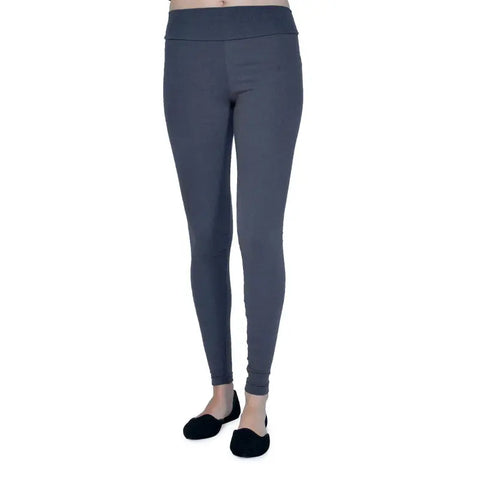 A person models Spiritex | Sustainable Apparel Yoga Leggings in gray with black slip-on shoes, standing against a white background; only the lower body is shown.