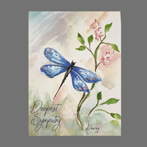 JuLu Cards Pack of 4 Deepest Sympathy cards (20052) features a watercolor blue dragonfly on a green stem with pink flowers and a pastel background, with Deepest Sympathy elegantly scripted in the bottom left corner.