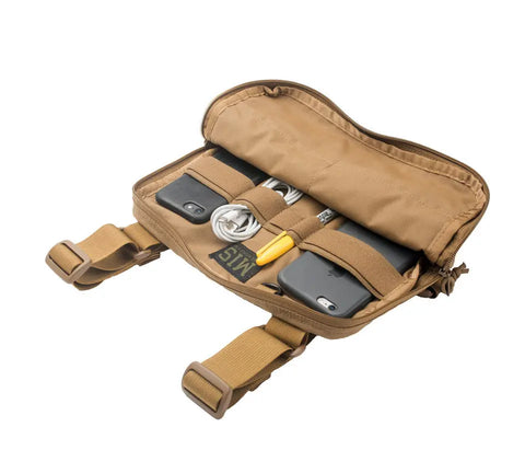 The MIS Chest Rig in Coyote Brown lies open, revealing its organized interior with two smartphones, a coiled cable, pen, patch, and other small items secured by elastic straps inside its durable Cordura Nylon construction.