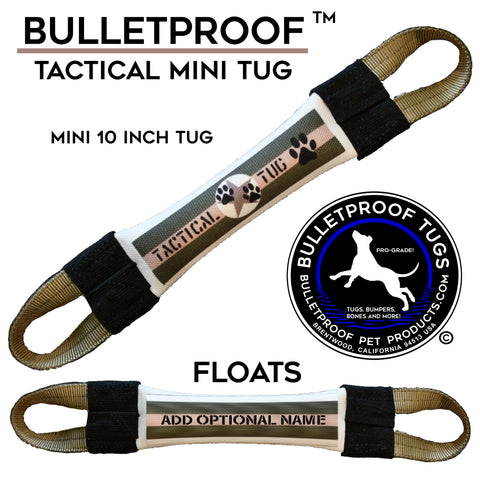The Mini Tactical Fire Hose Tug Toy by Bulletproof Pet Products Inc is a small, black and white dog toy with sturdy handles, labeled TACTICAL TUG with paw prints. It floats, measures 10, allows name customization, and is made in the USA.