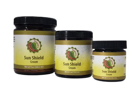 Three jars of Taspens Organics Sun Shield Cream, an organic mineral sunscreen for sensitive skin, are displayed in 9 oz, 4 oz, and 2 oz sizes with yellow and green labels on a white background.