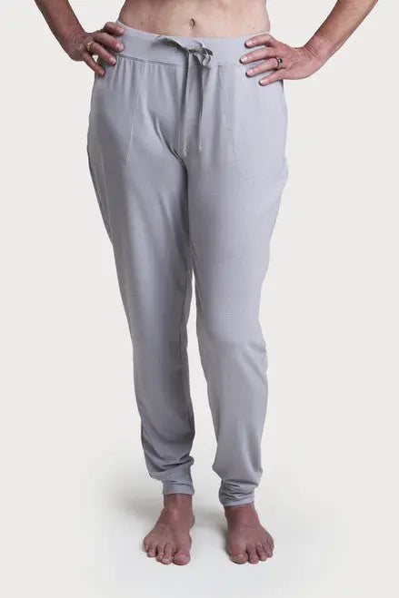 A person stands barefoot in Goodnighties Jogger Pants with pockets, made from 37.5 technology fabric, hands on hips against a plain white background.