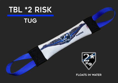 A Bulletproof Pet Products Inc Thin Blue Line Fire Hose Training Tug - Flag Series dog toy, white and blue with handles, labeled 2* K9, is shown on black. Text: TBL *2 RISK TUG, FLOATS IN WATER—ideal for law enforcement training.