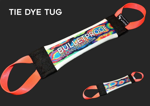 The Tie Dye Fire Hose Training Tug by Bulletproof Pet Products Inc is a USA-made, colorful dog tug toy with a tie-dye pattern, orange handles, and brand text—perfect for durable dog training. Black background with “TIE DYE TUG” in white letters.