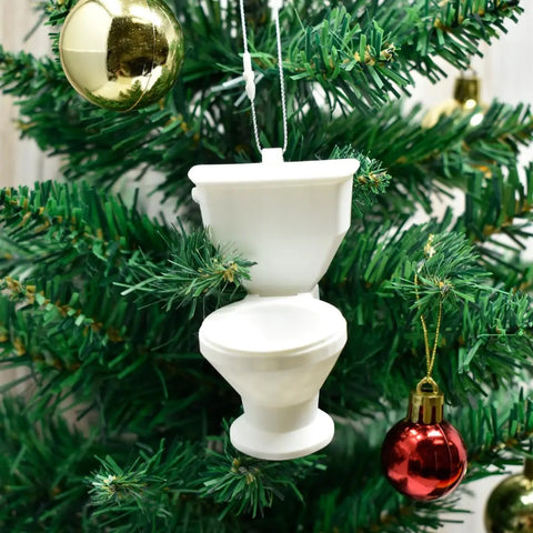 The Chatelet Manufacturing Toilet Bowl Christmas Tree Ornament hangs on a green tree, surrounded by classic gold and red round ornaments.