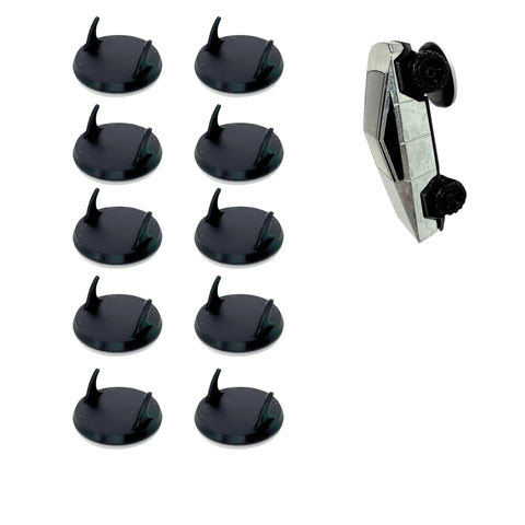 Nine black circular bases with vertical fins from Chatelet Manufacturings Toy Car Wall Display Organizer (compatible with Hot Wheels) are arranged on the left; a silver toy car with black wheels lies to the right against a white background.