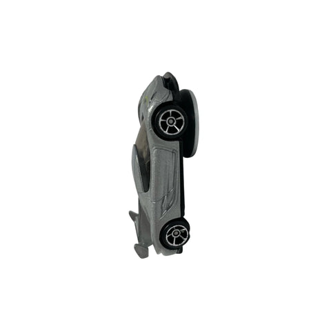 A small gray toy car stands vertically on its rear bumper against a plain white background, ideal for displaying on the Chatelet Manufacturing Toy Car Wall Display Organizer—compatible with Hot Wheels and easy to mount off the floor.