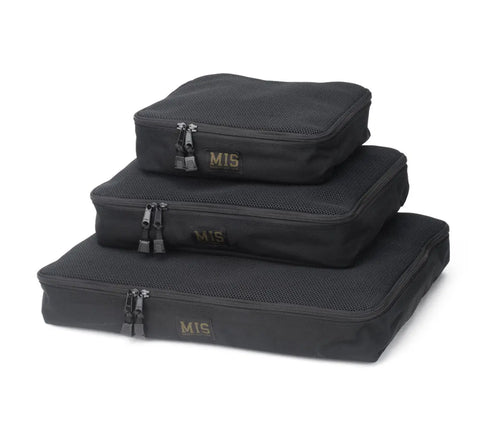 The MIS Organizer Set - Black includes three water-resistant, mesh-top packing cubes of different sizes, made in the USA, each labeled MIS in gold. They are shown stacked together.