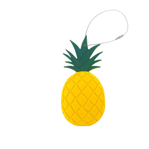 A bright yellow pineapple-shaped luggage tag by Chatelet Manufacturing, inspired by the Pineapple Christmas Ornament—Decorative Holiday Ornament Made in the USA—with a green top and silver looped strap, shown on a white background.