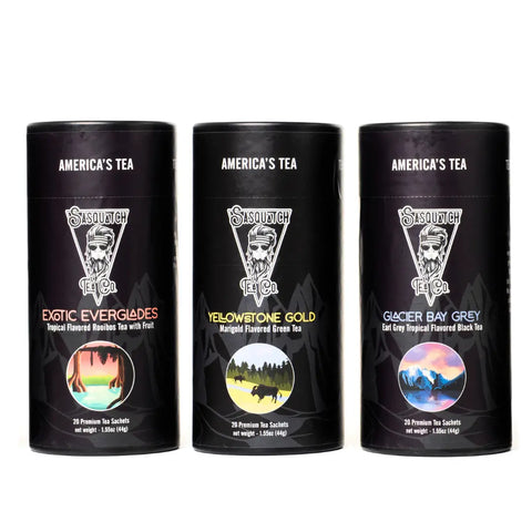 The Tropical Tea Bundle from Sasquatch Tea Co features three black cylindrical canisters, each with unique label artwork and white text on black backgrounds.
