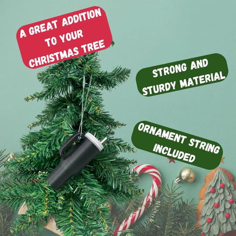 A Tumbler Cup Replica Christmas Ornament by Chatelet Manufacturing hangs on a tree with festive decor. Made in USA, its sturdy and includes an ornament string—a great 2023 water bottle holiday addition to your Christmas tree.