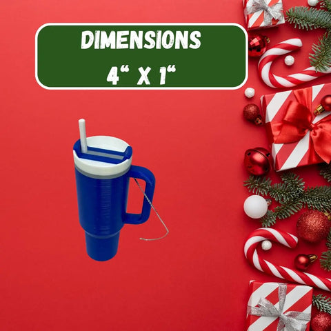 The Chatelet Manufacturing Tumbler Cup Replica Christmas Ornament—a blue ornament with straw and handle—is shown on a red background with holiday decor, gifts, and a sign above reading DIMENSIONS 4” X 1” in white on green. Made in USA.