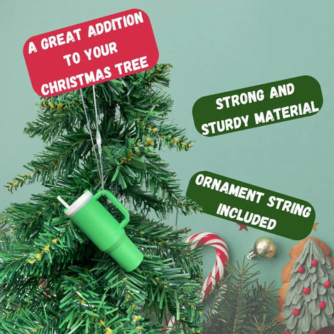 A Tumbler Cup Replica Christmas Ornament by Chatelet Manufacturing hangs on a tree, featuring sturdy construction and an included string. Add this popular 2023 water bottle mug ornament, made in the USA, to your festive holiday decor!.