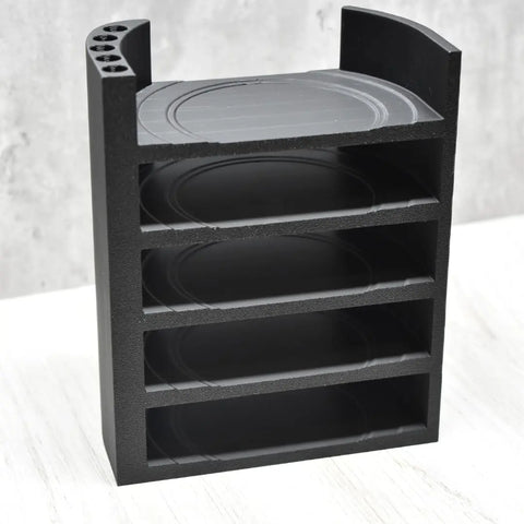 The Chatelet Manufacturing Lid Organizer Rack, compatible with all Yeti Rambler & Tumbler lids and metal straws, features five black shelves and curved sides. Made in the USA, it sits on a white surface against a light gray background.