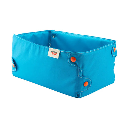 The Whisker+Box Turquoise Blue With Orange Snaps is a rectangular fabric cat box with orange snap buttons and a small white label on the side, shown empty against a white background.