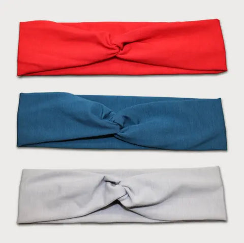 The Goodnighties Twist Headband 3-Pack features American-made hair accessories in red, blue, and light gray, each with a central twisted knot, displayed flat in a row against a neutral background.