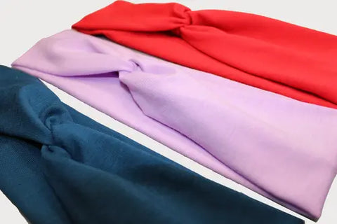 The Goodnighties Twist Headband 3-Pack includes stylish American-made hair accessories in red, lavender, and dark teal—perfect for any occasion.