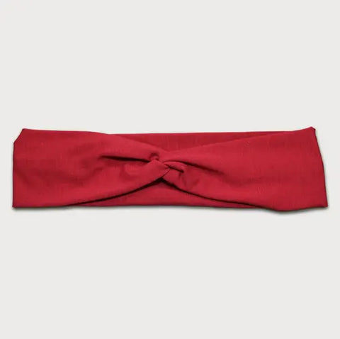 The Goodnighties Twist Headband features a soft, lightweight red fabric with a central knot design, shown laid flat on a plain white background.