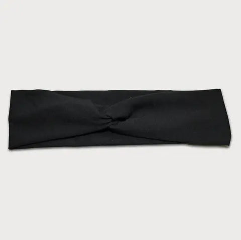 The Goodnighties Twist Headband is a soft, lightweight black hair accessory with a knotted center, shown on a light gray background. Made in the USA.