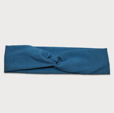 The Goodnighties Twist Headband is a soft, lightweight blue hair accessory featuring a central twisted knot, made in the USA—perfect for everyday style. Displayed on a plain light background.