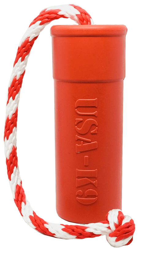 The SodaPup USA-K9 Firecracker Durable Rubber Floating Training Dummy, Large in Red, is a cylindrical toy with USA-K9 embossed, featuring a red and white braided rope knotted at the end.
