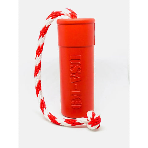 The SodaPup USA-K9 Firecracker TNT Training Dummy is a large, red, cylindrical floating toy with USA-K9 embossed on the side and a white and red braided rope attached to one end.