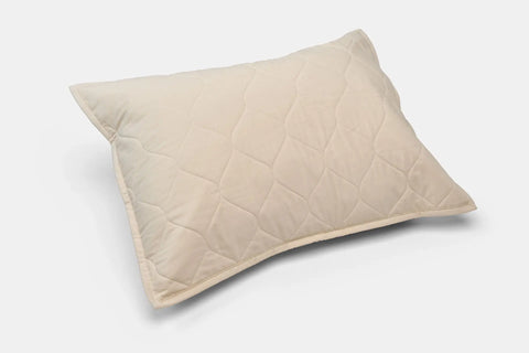 A beige, rectangular Cotton Quilted Pillow Sham by American Blossom Linens is shown on a plain white background, featuring a quilted diamond-patterned cover made from eco-friendly USA-grown cotton.