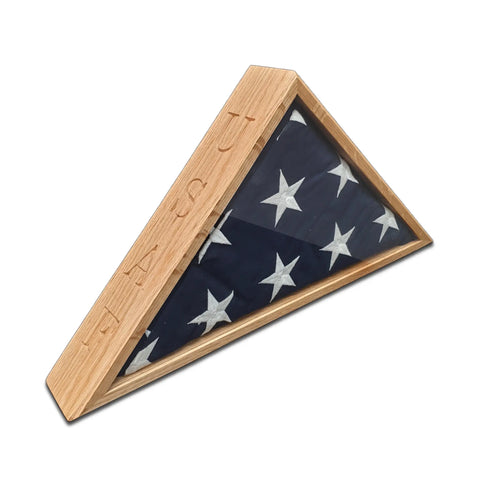 A folded 5 x 9.5 flag rests in the USAF - Oak Burial Flag Display Case by Legacies of America Woodworking Company, honoring American legacy with veteran handcraftsmanship and engraved wood details.