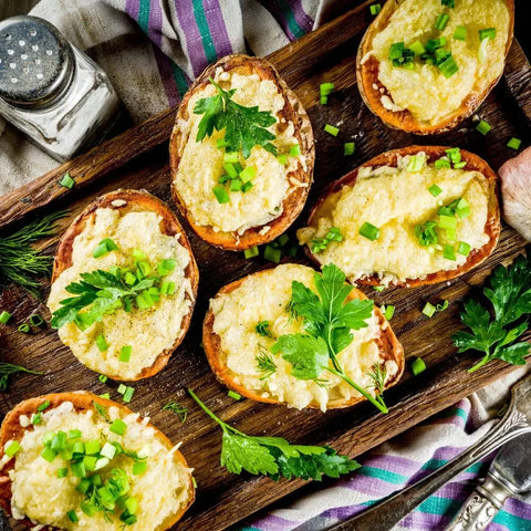 Six baked potato halves topped with cheese, green onions, and parsley are served on a wooden tray, finished with Veggie Lovers Seasonings - 3 Pack by vendor-unknown for extra veggie flavor.