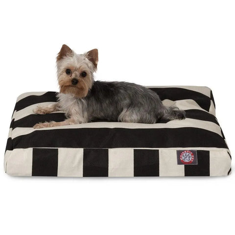 A small dog with gray and tan fur is lying on a Majestic Pet Vertical Stripe Rectangle Dog Bed, featuring black-and-white stripes and filled with Premium Polyester Fiber Fill for comfort.