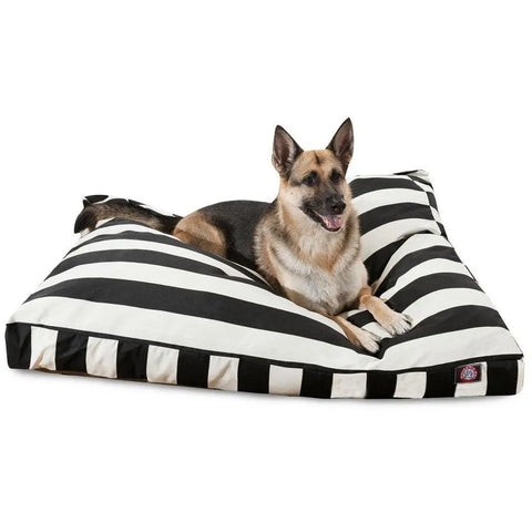 A German Shepherd lies alert and happy, tongue out, on the Majestic Pet Vertical Stripe Rectangle Dog Bed featuring a large, black and white striped washable cover.