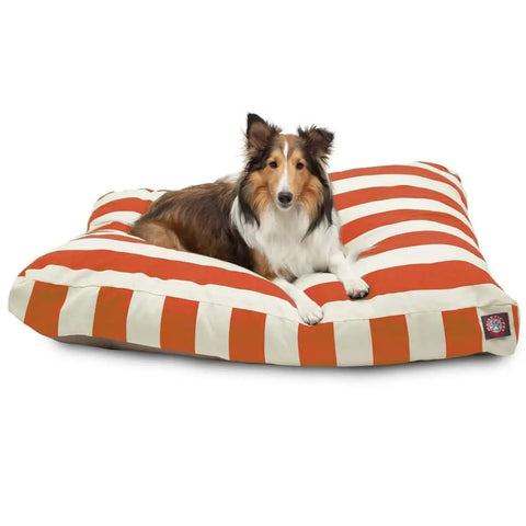 A brown and white Collie lies comfortably on the Majestic Pet Vertical Stripe Rectangle Dog Bed, featuring a washable red and white striped cover, against a white background.