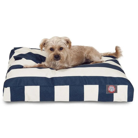 A small, light brown dog is lying on the Majestic Pet Vertical Stripe Rectangle Dog Bed with wide black and white stripes and a washable cover, set against a white background.