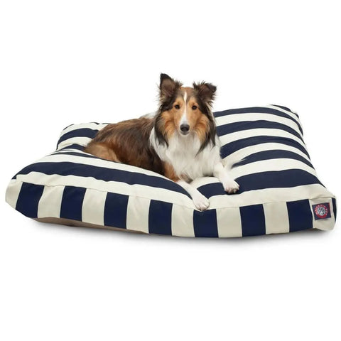 A brown and white dog is lying on the Majestic Pet Vertical Stripe Rectangle Dog Bed, which features bold navy blue and white stripes and premium polyester fiber fill for comfort.