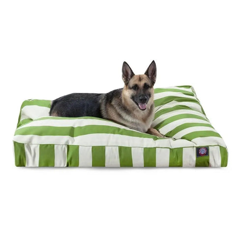 A German Shepherd lies on the Majestic Pet Vertical Stripe Rectangle Dog Bed, featuring green and white stripes and a washable cover, resting comfortably with its mouth slightly open.