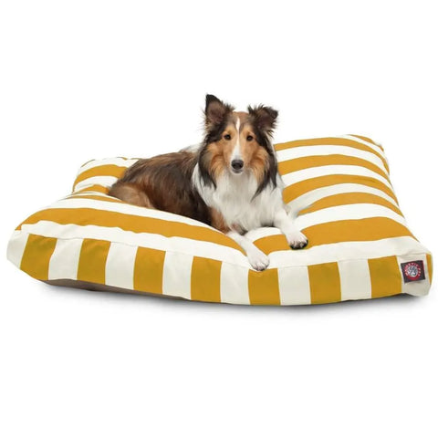 A brown and white dog relaxes on the Majestic Pet Vertical Stripe Rectangle Dog Bed, featuring yellow and white stripes, cozy polyester fill, and a washable cover.