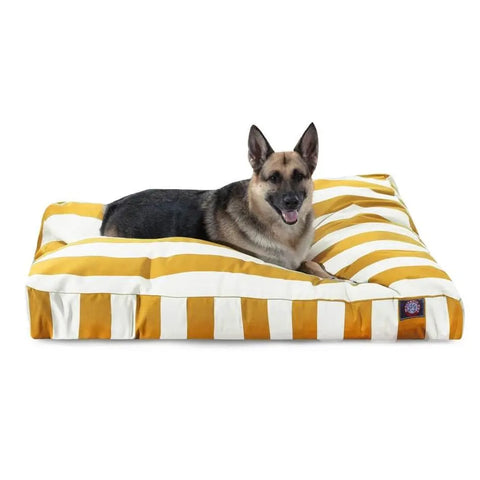 A German Shepherd lies on the Majestic Pet Vertical Stripe Rectangle Dog Bed, featuring bold yellow and white stripes, a washable cover, and soft polyester fill for easy care and cozy comfort.